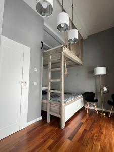 a room with a bunk bed and a chair at Stodola Klokočí in Klokočí