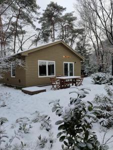una piccola baita con un tavolo da picnic nella neve di De Spetser a Merksplas