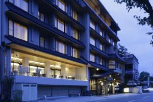 un grand bâtiment avec des tables et des chaises devant lui dans l'établissement Fujikawaguchiko Onsen Konanso, à Fujikawaguchiko