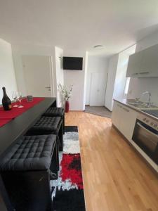 a living room with a black couch and a kitchen at Klein und Fein in Hartberg