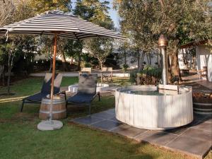 an umbrella and two chairs and a tub in a yard at OLYF accommodation in Bloemfontein