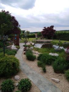 a garden with a pond and a walkway around it at Klein und Fein in Hartberg