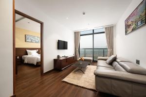 a living room with a couch and a bed and a mirror at Elegance Ninh Binh Hotel in Kỳ Vĩ