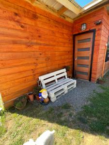 a wooden cabin with a bench next to a door at Cabañas Maite Panguipulli Calafquen 2 in Huellahue