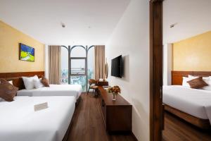 a hotel room with two beds and a tv at Elegance Ninh Binh Hotel in Kỳ Vĩ