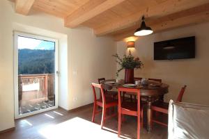 a dining room with a table and a large window at Casa Tomà Mountain View Cortina in San Vito di Cadore