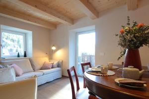 a living room with a table and a couch at Casa Tomà Mountain View Cortina in San Vito di Cadore