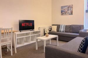 a living room with a couch and a tv at Euston Road - Beach Apartment 9 in Great Yarmouth