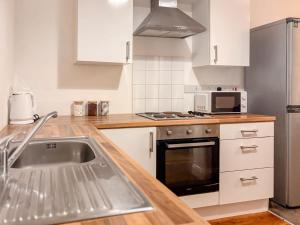 a kitchen with a sink and a stainless steel refrigerator at Euston Road - Beach Apartment 9 in Great Yarmouth +1 photo