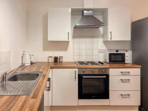 a kitchen with a sink and a microwave at Euston Road - Beach Apartment 9 in Great Yarmouth