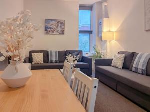 a living room with a table and a couch at Euston Road - Beach Apartment 9 in Great Yarmouth