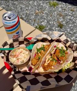 a sandwich and coleslaw on a table with a soda at Salt & Pine in Mathews, VA in Blackwater