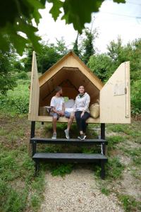 two men sitting in a bed in a tent at Agronidi Baladin StarsBox in Piozzo