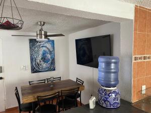 a dining room with a table with a blue and white vase at DEPA IXTLAN alberca y cerca de playa in Santa Cruz Huatulco