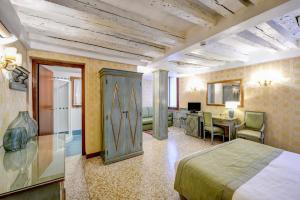 a hotel room with a bed and a desk at Locanda La Corte in Venice