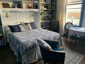 a bedroom with a bed and a chair and a table at Het Twiscker Huys in Twisk