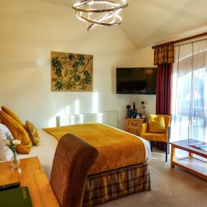 a bedroom with a bed and a desk and a tv at Oak Tree Inn in Brafferton