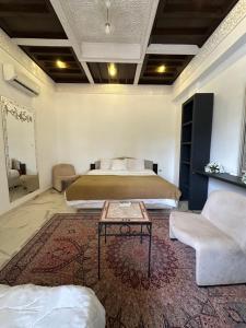 a bedroom with a bed and a table and a couch at Fekhara CC in Marrakesh