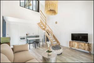 a living room with a couch and a staircase at TI KASA et SPA in Andernos-les-Bains