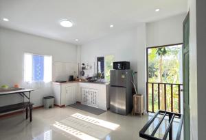 a kitchen with a stainless steel refrigerator and white cabinets at Baan Lanta in Ko Po
