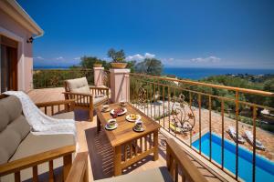 a patio with a table and chairs on a balcony at Villa Androniki in Longós