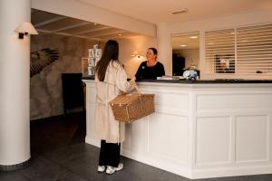 a woman standing at a counter in a kitchen at Noordzee, Hotel & Spa in Cadzand-Bad