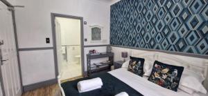 a bedroom with a bed and a blue and white wall at LilyRose Hotel in Whitby