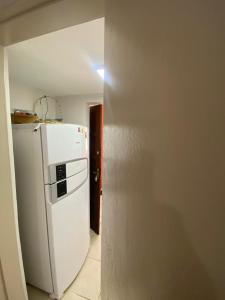 a kitchen with a white refrigerator in a room at Mar e Descanso in Guarapari