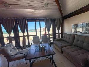 a living room with a couch and chairs and a table at Mar e Descanso in Guarapari