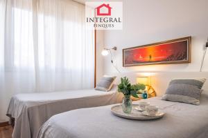 two beds in a room with a table with a plate on it at Why Not Apartment Palamós in Palamós