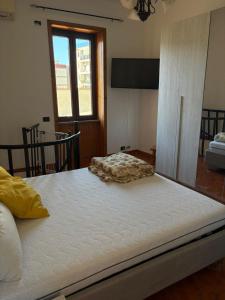 ein großes weißes Bett in einem Zimmer mit Fenster in der Unterkunft Domus Sofia in Ercolano