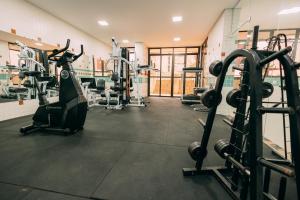 a gym with treadmills and machines in a room at Eco Stay in Curitiba