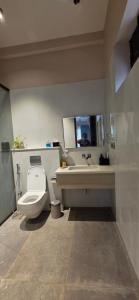 a bathroom with a toilet and a sink at Nirmala's Farmhouse - The Blu room in Kuttālam +5 photos