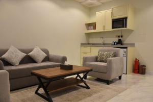 a living room with a couch and two chairs and a table at غيمة in Hail