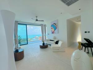 a white living room with a view of the ocean at Mountain Top Villa in Bophut