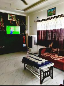 a living room with a couch and a tv at Haripriya Guest House 2bhk Solapur in Bāle
