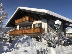 a house covered in snow with a pile of snow at Landhaus Elisabeth in Krün