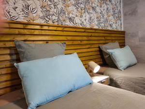 a room with two beds and a wall at Ti Kaz Luxuriante - Jacuzzi Privé - Évasion Tropicale & Intimité in Saint-Louis