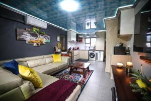 a living room with a couch and a kitchen at Heated Pool Luxury Retreat - 7 Min from OR Tambo in Benoni