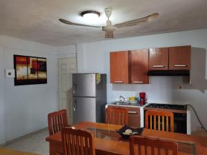 a kitchen with a table and a stainless steel refrigerator at Casa Aca in Acapulco