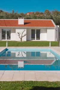 a villa with a swimming pool in front of a house at Casa Cabeça in Macedo de Cavaleiros