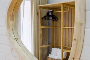 a wooden shelf with a mirror in front of a window at Novus Homes Barcelona Santa Eulalia in Hospitalet de Llobregat