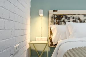 a bedside table with a clock on it next to a bed at Novus Homes Barcelona Santa Eulalia in Hospitalet de Llobregat +130 photos