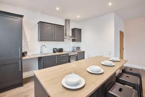 a kitchen with a table with plates and wine glasses on it at Host & Stay - Promenade Suite in Blackpool +20 photos