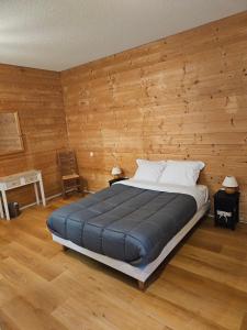 a bedroom with a large bed with wooden walls at Auberge de Pontgibaud in Lathuile