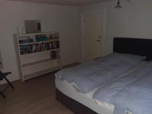 a bedroom with a bed and a book shelf at Stor lejlighed ved togstation in Viborg