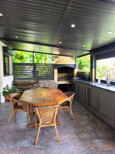 a kitchen with a table and chairs and a sink at Ti Kaz Luxuriante - Jacuzzi Privé - Évasion Tropicale & Intimité in Saint-Louis