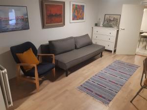 a living room with a couch and a chair at Stor lejlighed ved togstation in Viborg