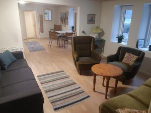 a living room with a couch and chairs and a table at Stor lejlighed ved togstation in Viborg