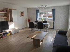 a living room with a table and chairs and a couch at Ferienwohnung DORFWIESE in NuÃŸbaum